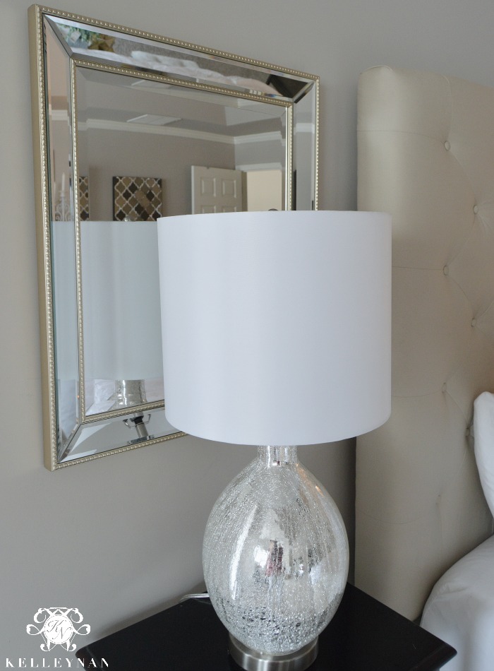 Lamp and mirror beside bed