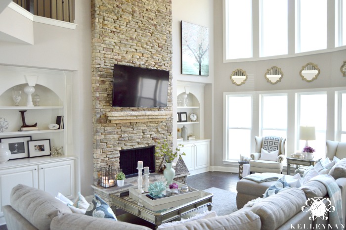 Two Story Living Room with stacked stone fireplace and built-ins Airy Elegant Living room