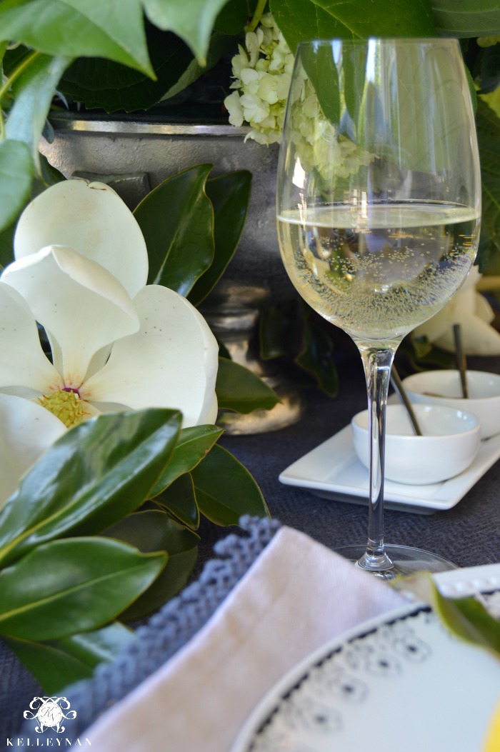 Magnolia blossom and white wine on outdoor table