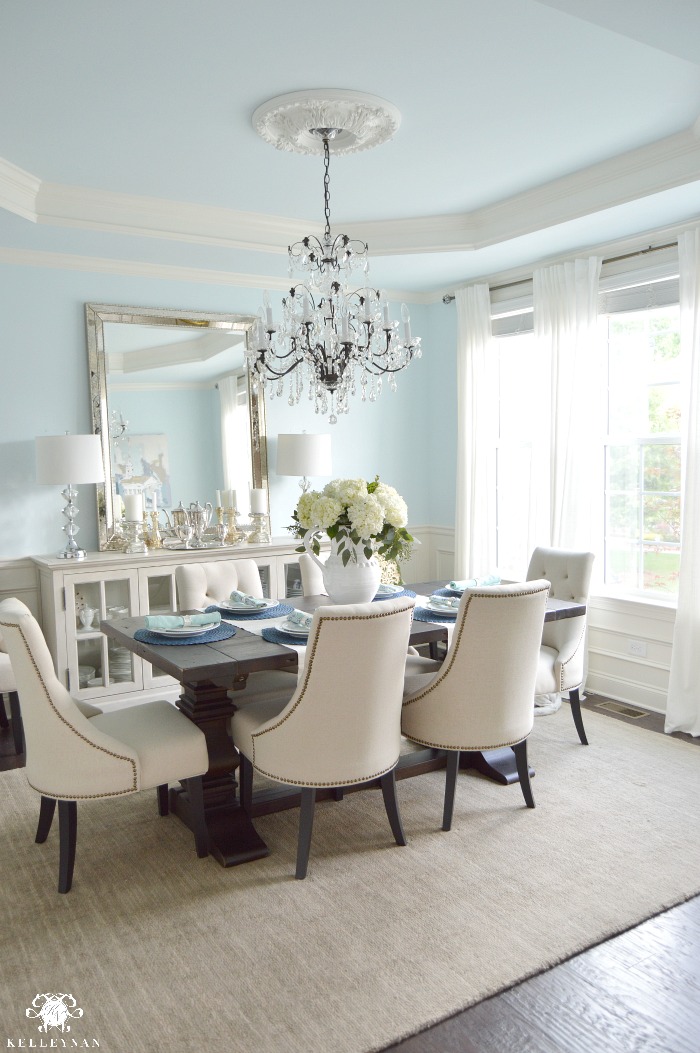 Blue Elegant Dining Room with White Hydrangeas and Vertical Mirror Over Cream Buffet