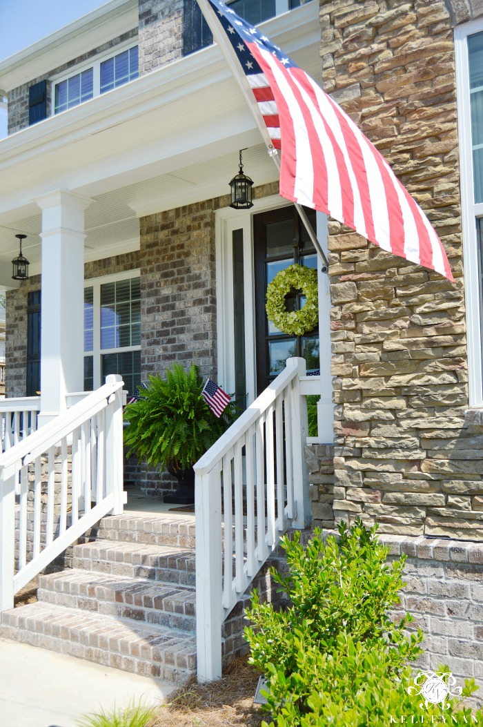 Front Porch with Ferns and American Flags- Craftsman Style Brick and Stone Home Elevation