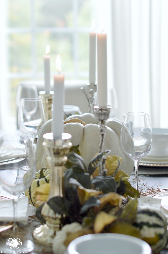 green-fall-tablescape-with-candles-and-pumpkins-with-leaves