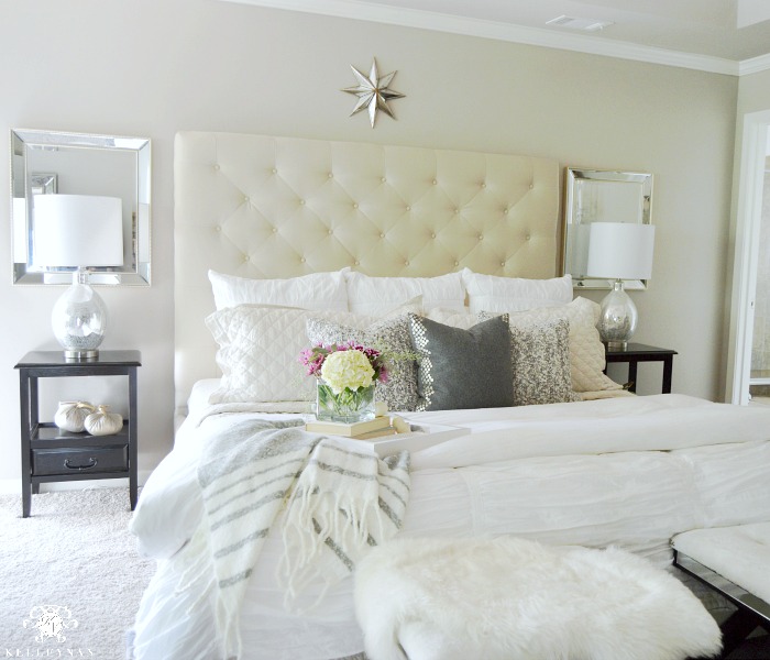 neutral-master-bedroom-with-tufted-headboard-and-lamps-and-mirrors-on-either-side-of-bed