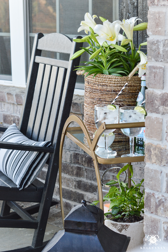 Spring Decorated Rocking Chair Front Porch with a Gold Bar Cart with plants and drinks