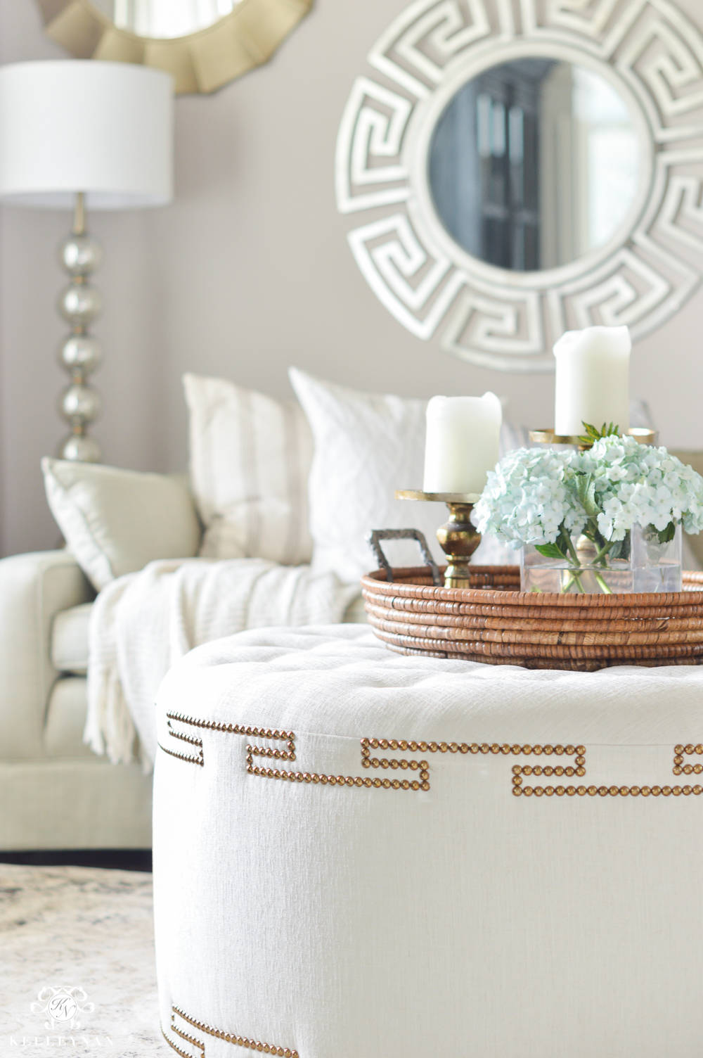 Shades of Summer Home Tour with Neutrals and Naturals-tufted coffee table ottoman in sitting room with mirror gallery wall