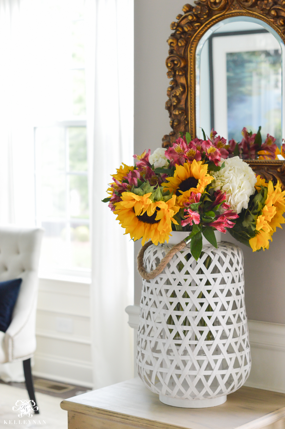 Floral Arrangement in Lantern- large white woven lantern in foyer with flowers