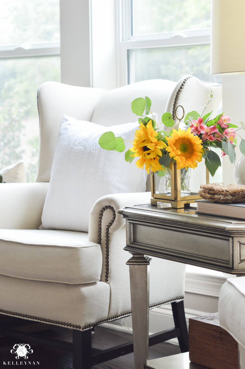 Floral Arrangement in Lantern- living room flowers in gold Pottery Barn lantern and wingback chair