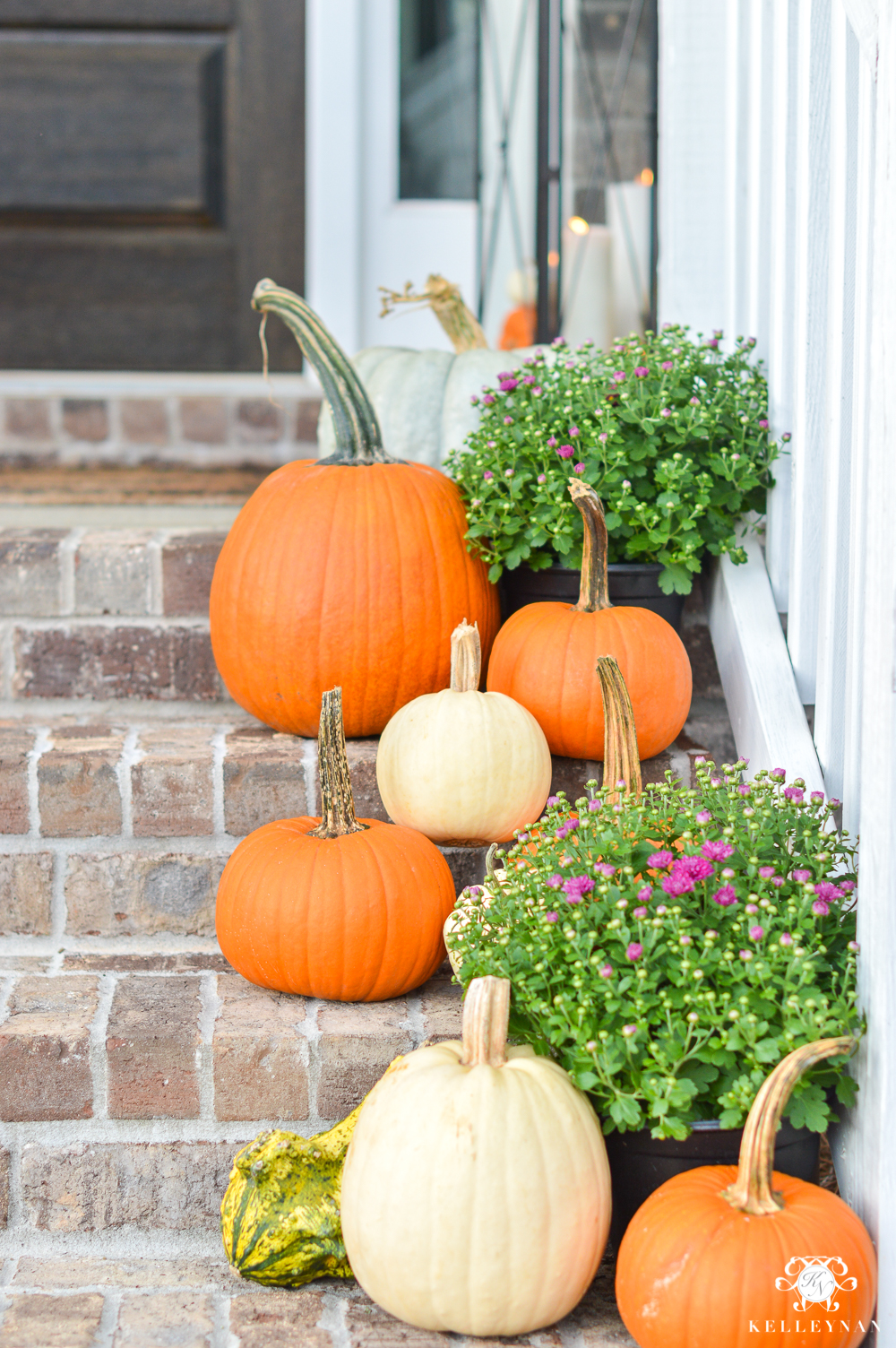 Fall front porch decor with pumpkins and purple mums