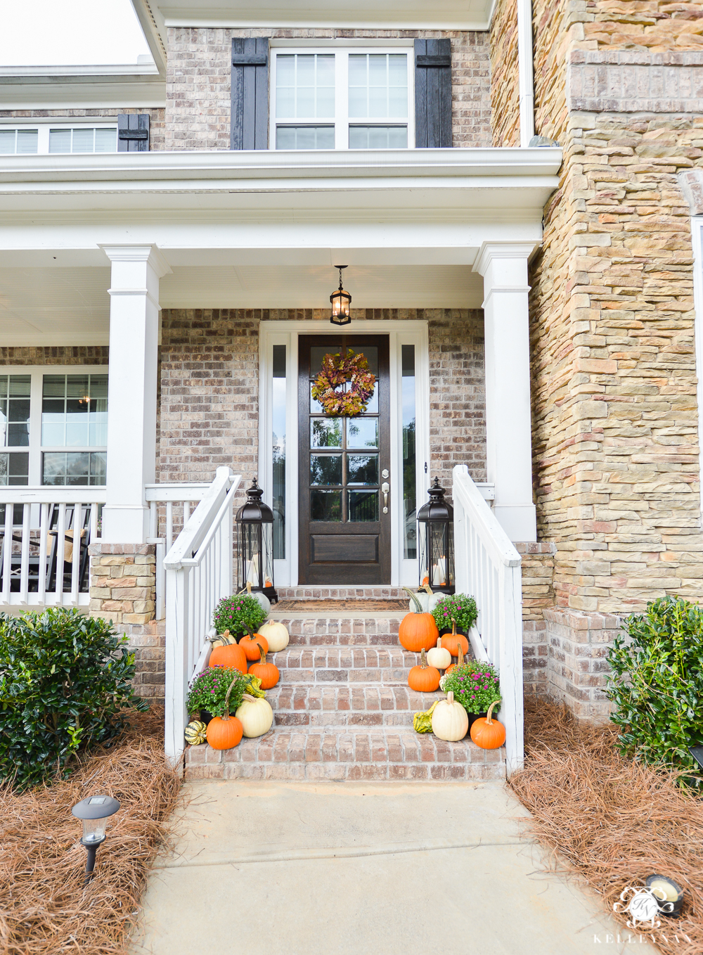 Fall front door and step decor with pumpkins and purple flowers