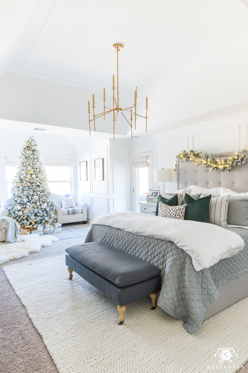 Gray and white Christmas bedroom with a pop of green and modern chandelier