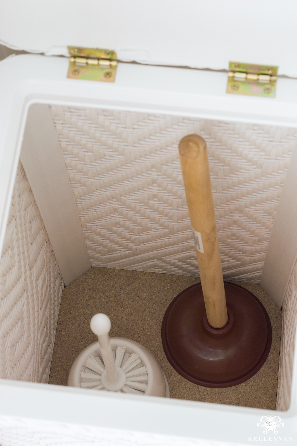 Using a hamper as a clever storage solution for bathroom plunger and toilet brush