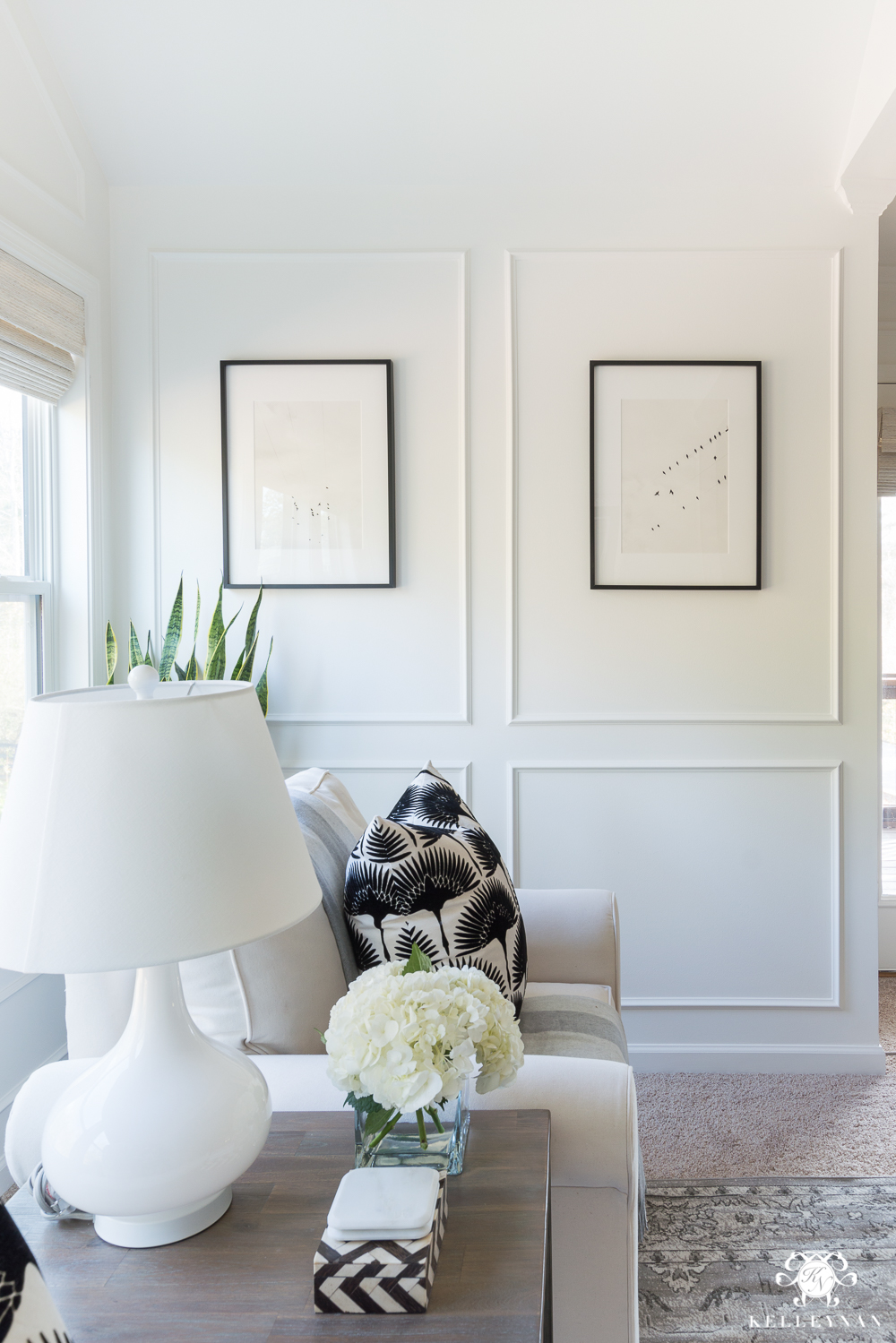 Bedroom sitting nook with white panel molding in Benjamin Moore Simply White paint