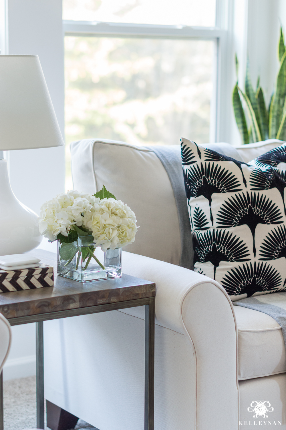 Black and white tonic living flock bird pillow in oversized chair