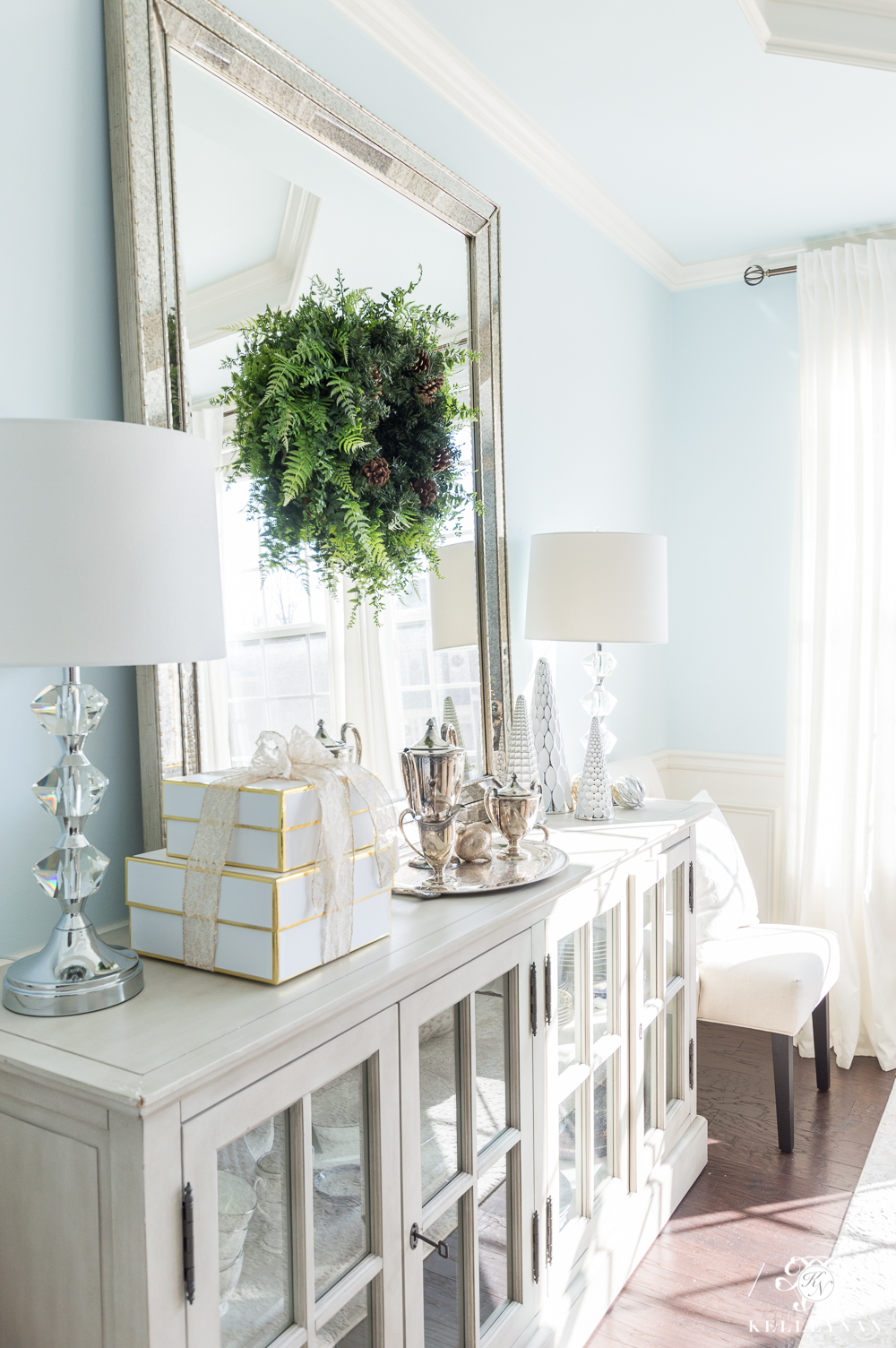 Elegant dining room buffet with Christmas decor and leaning mirror