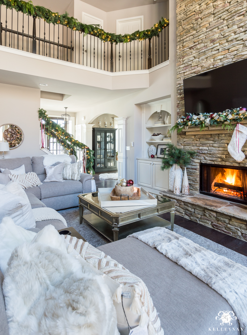 Christmas living room with garland on banisters and on mantel