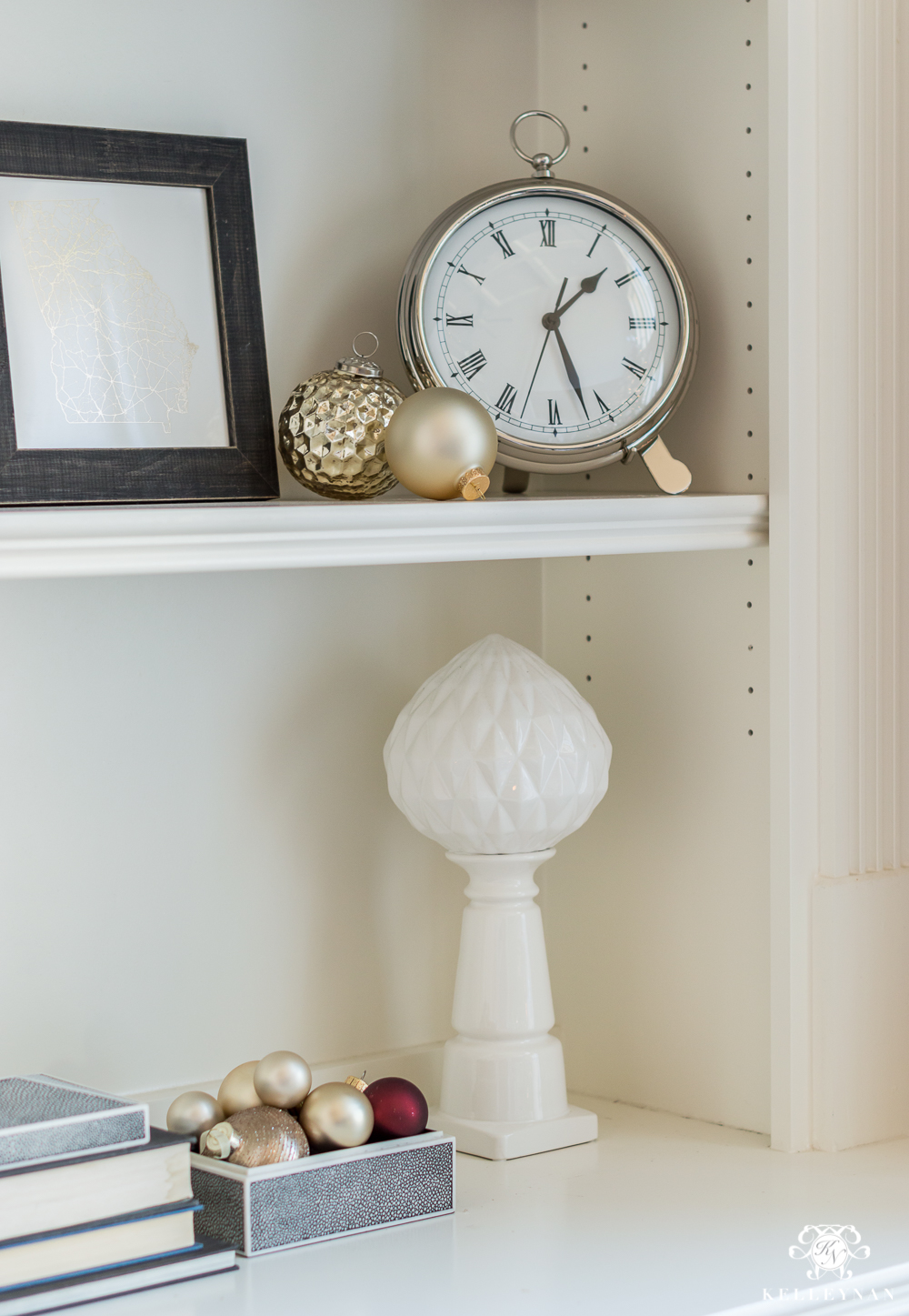 Christmas ornaments on styled bookshelves