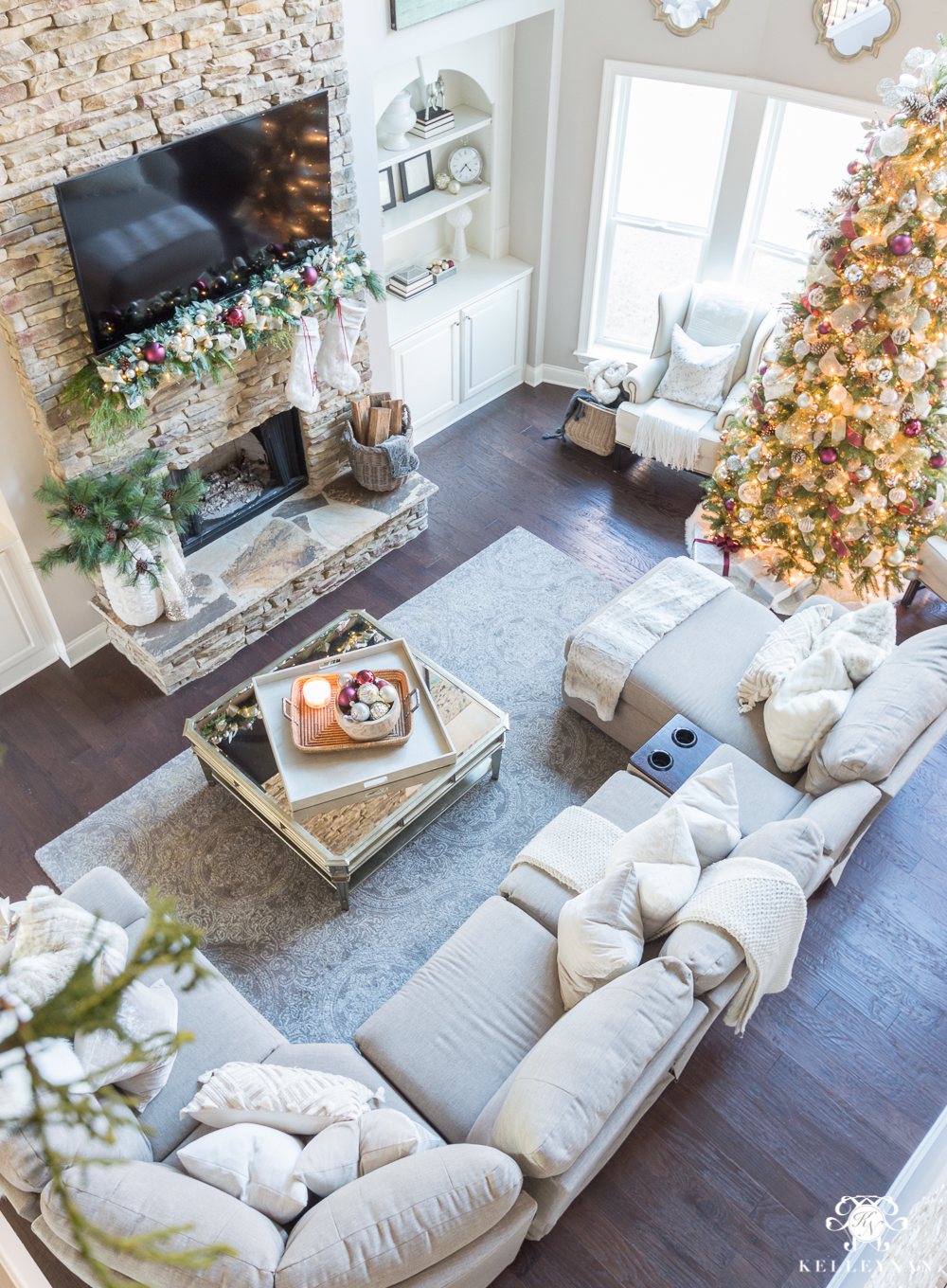 Two story Christmas living room with lazboy sectional and stacked stone fireplace