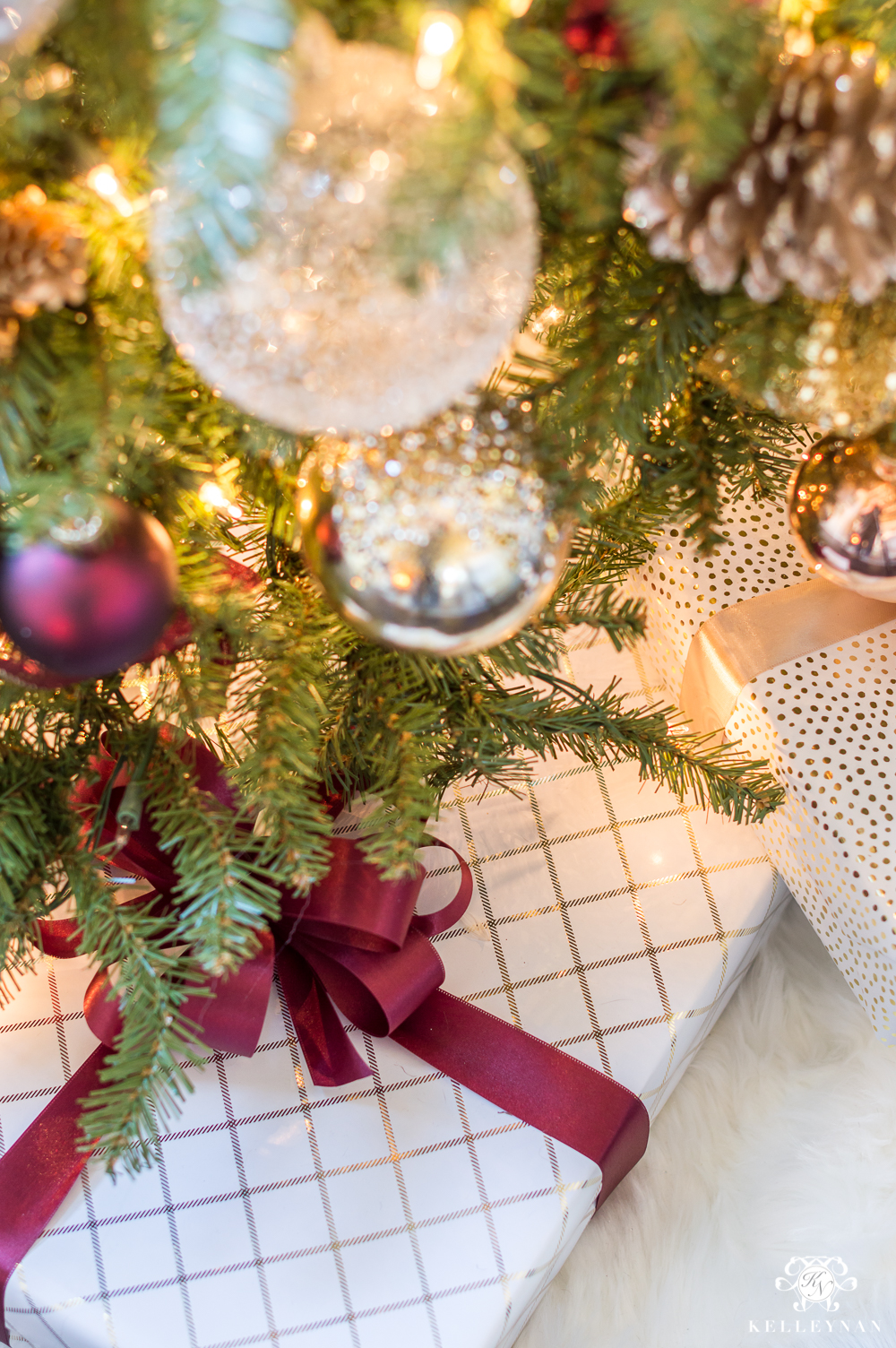 Christmas gifts under the tree with wine ribbon