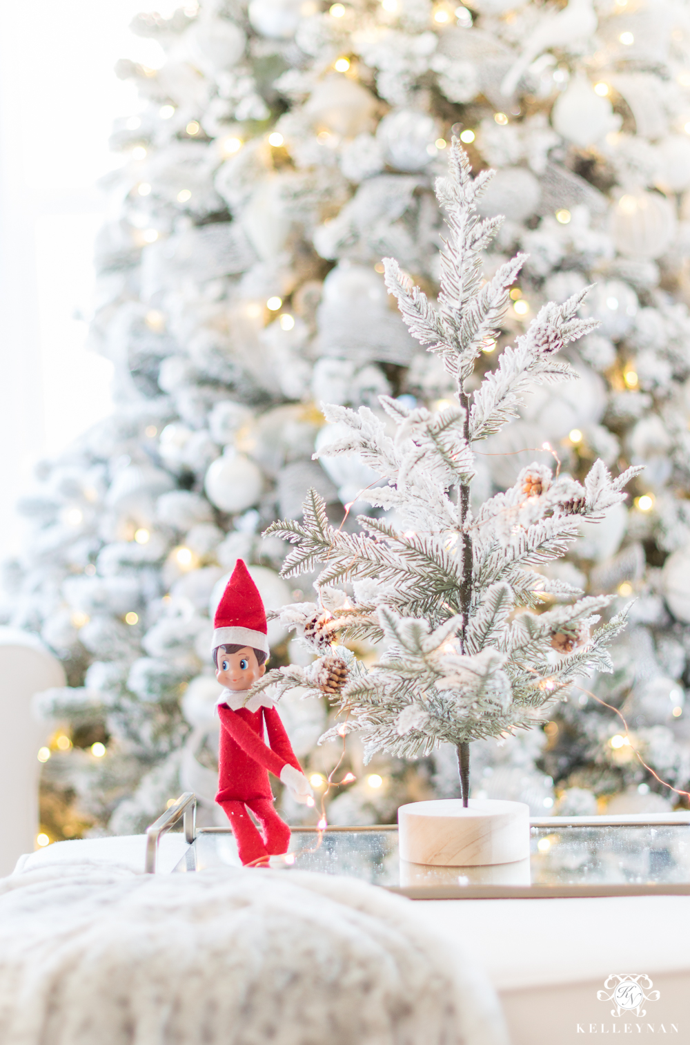 Elf on the shelf decorating a christmas tree