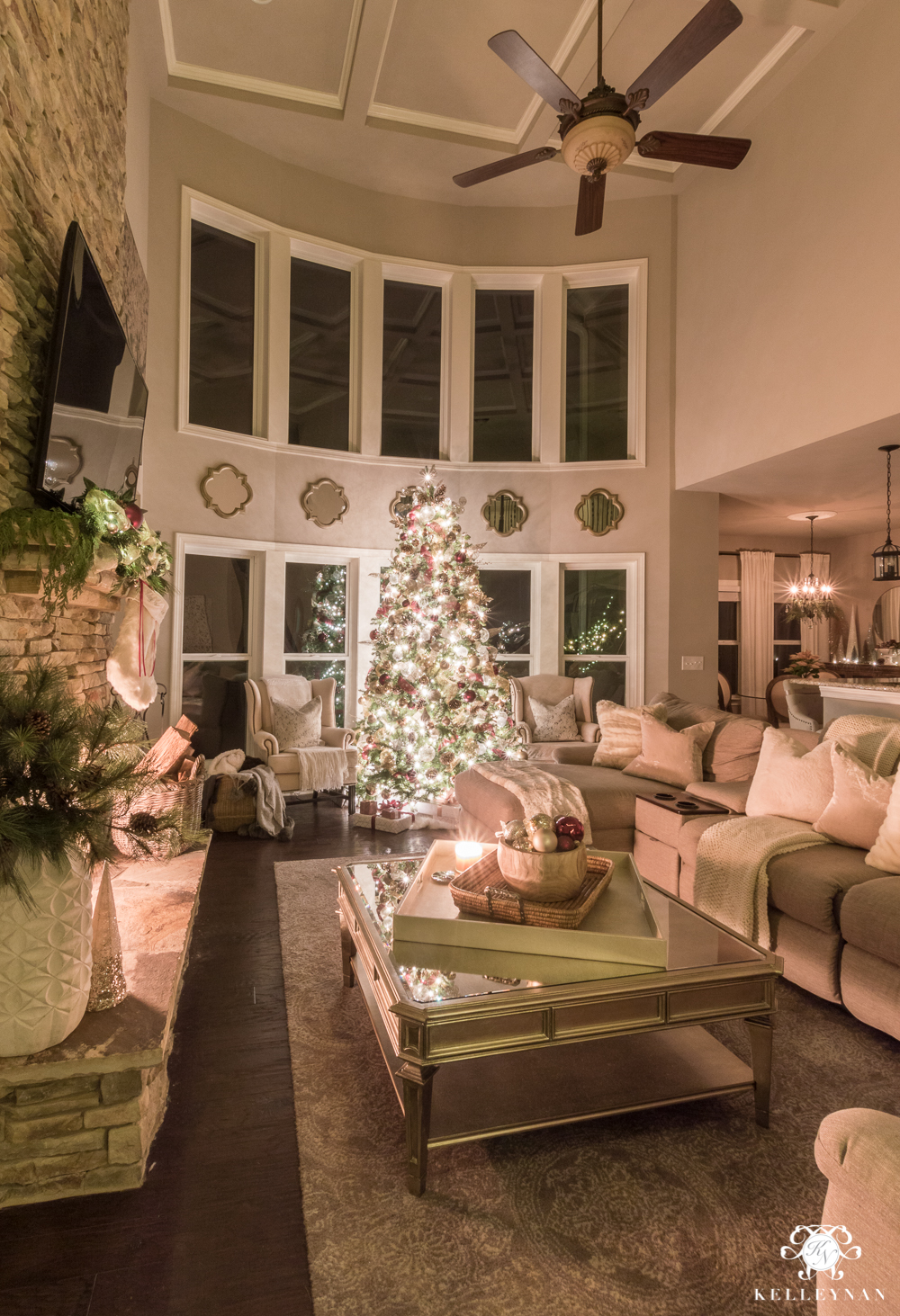 Two story living room with bay window and huge christmas tree