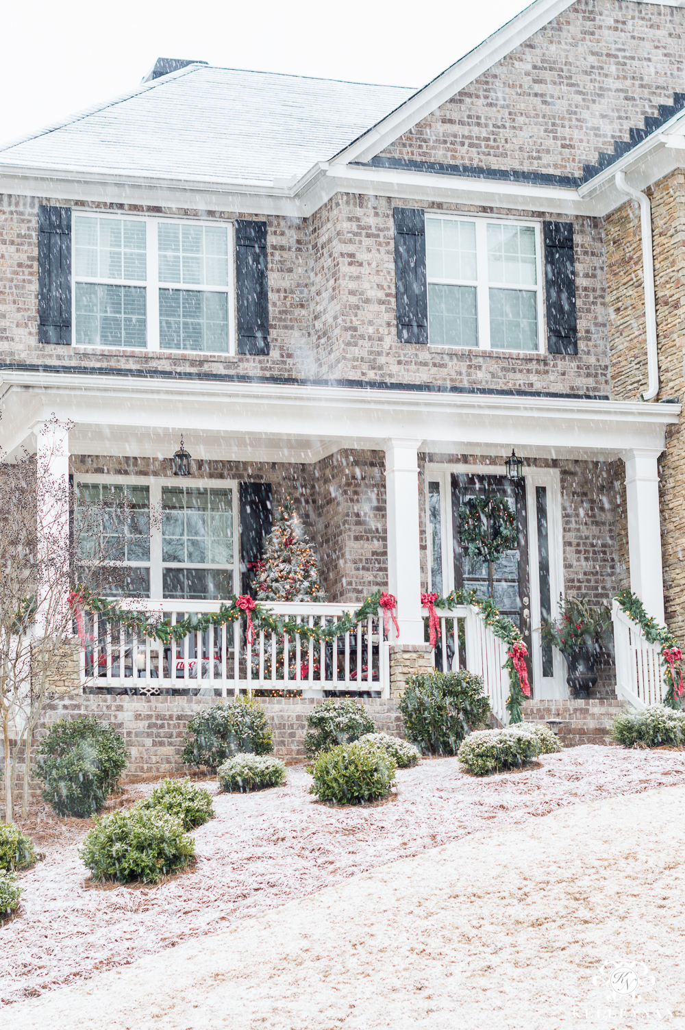 Snowy Christmas Front Porch on Brick Home with Traditional Decorations