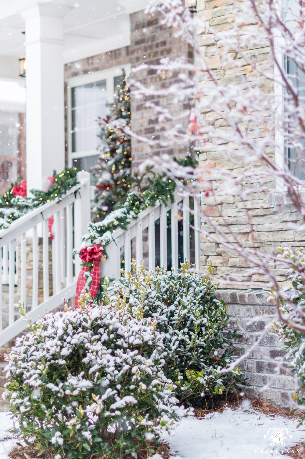 Snowy Christmas Front Porch with Red Bows on Railing