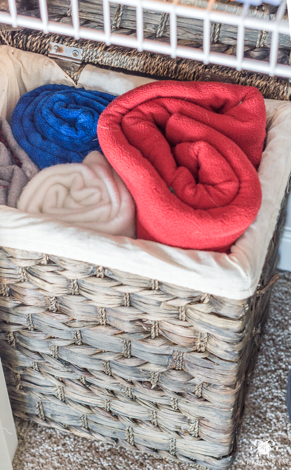 Dog blankets organized in a hamper in the linen closet