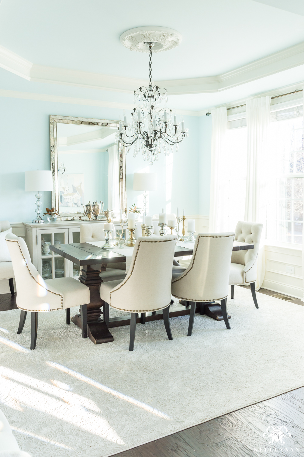 Elegant blue dining room design with cream chairs and crystal chandelier