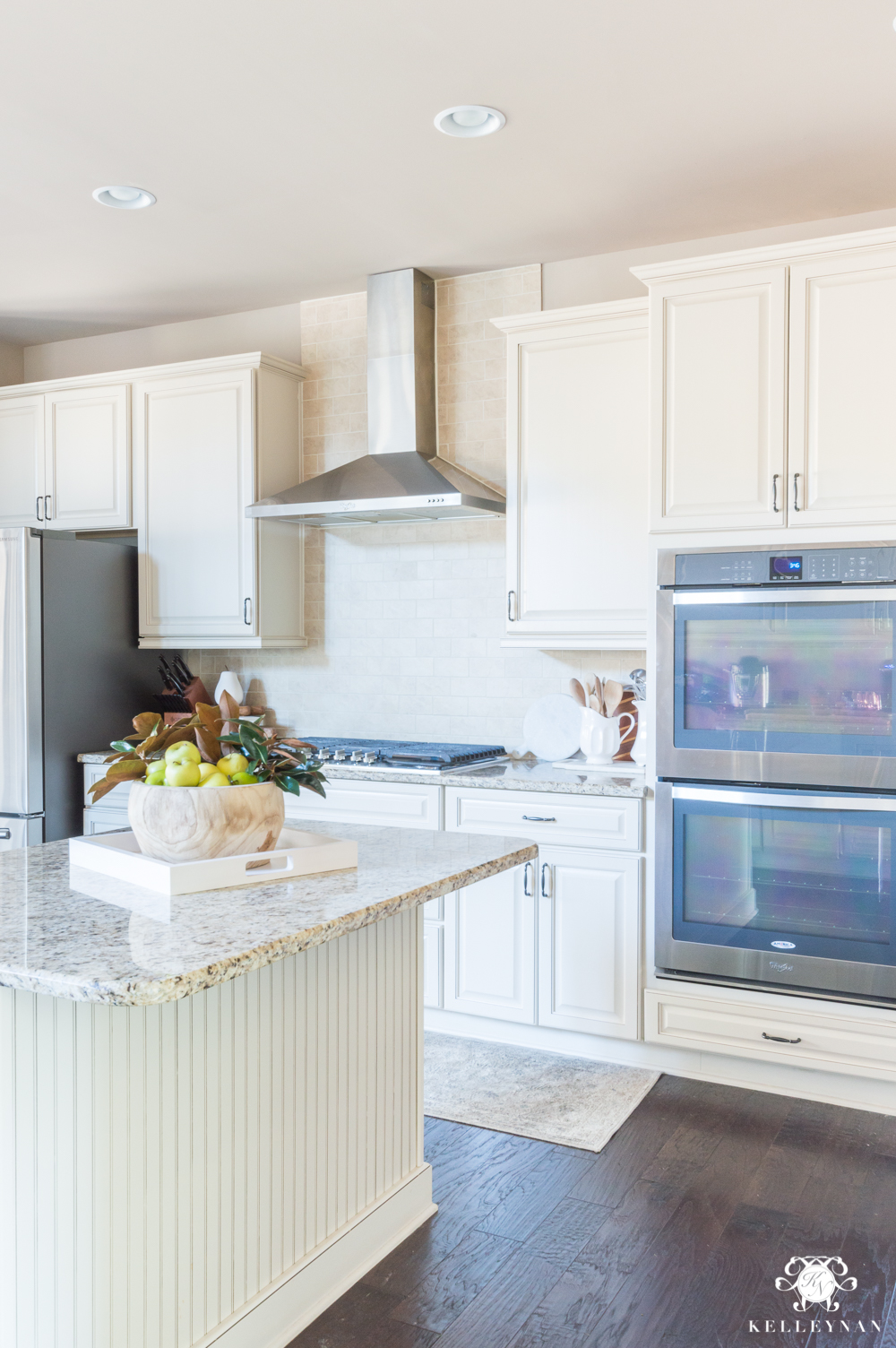 Neutral kitchen decorating ideas with SW Perfect Greige paint, cream cabinets, and dark hardwood floors