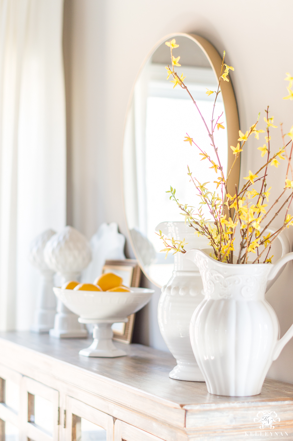 Breakfast Room Sideboard with Yellow Forsythia and Round Brass Mirror