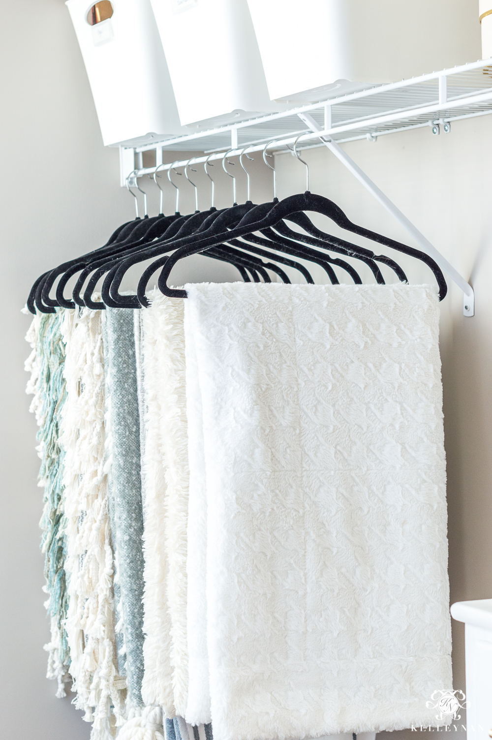 Hanging throw blankets in the closet for storage and organization