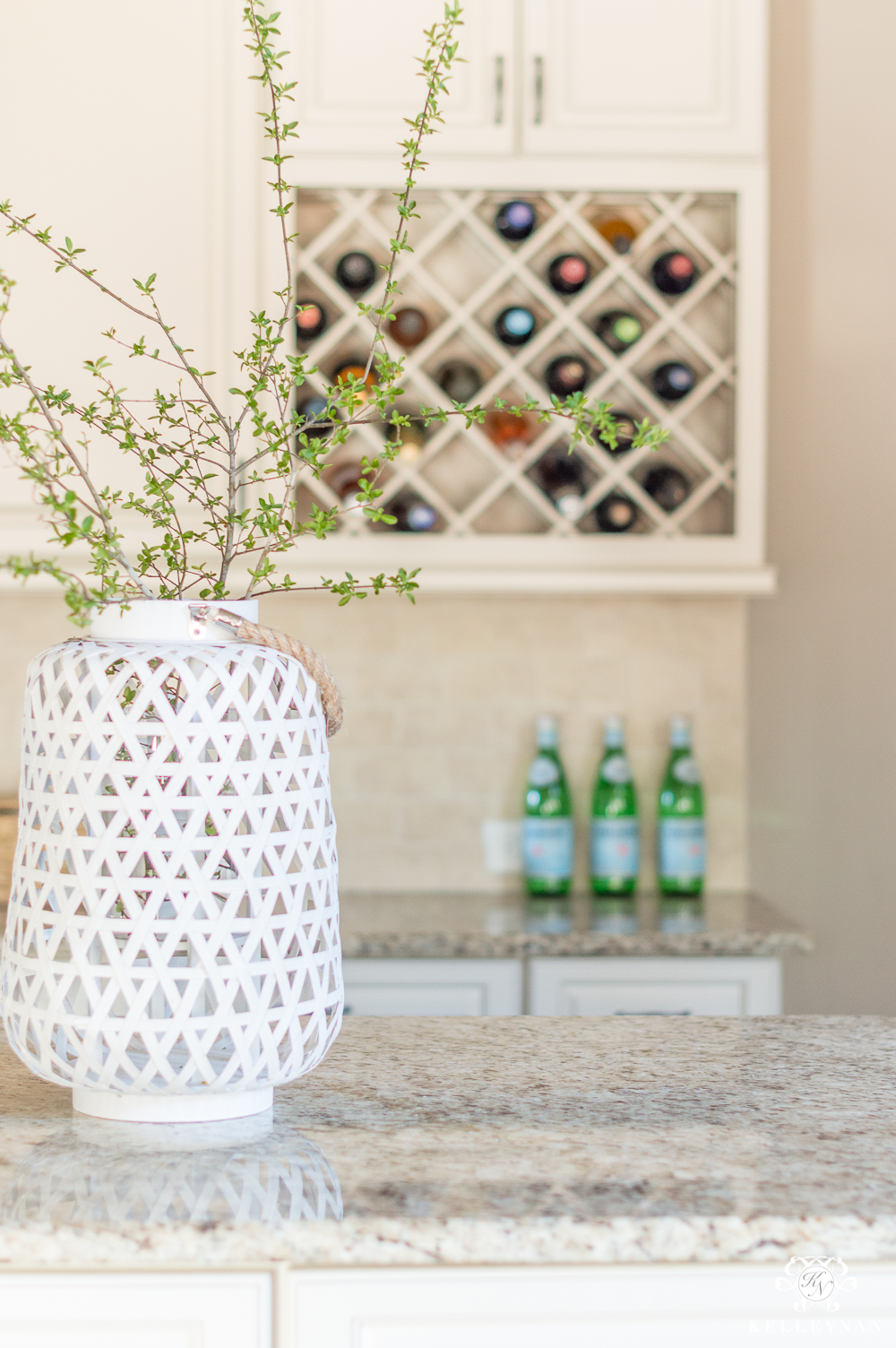 White Bamboo Lantern with Green Branches on Kitchen Island