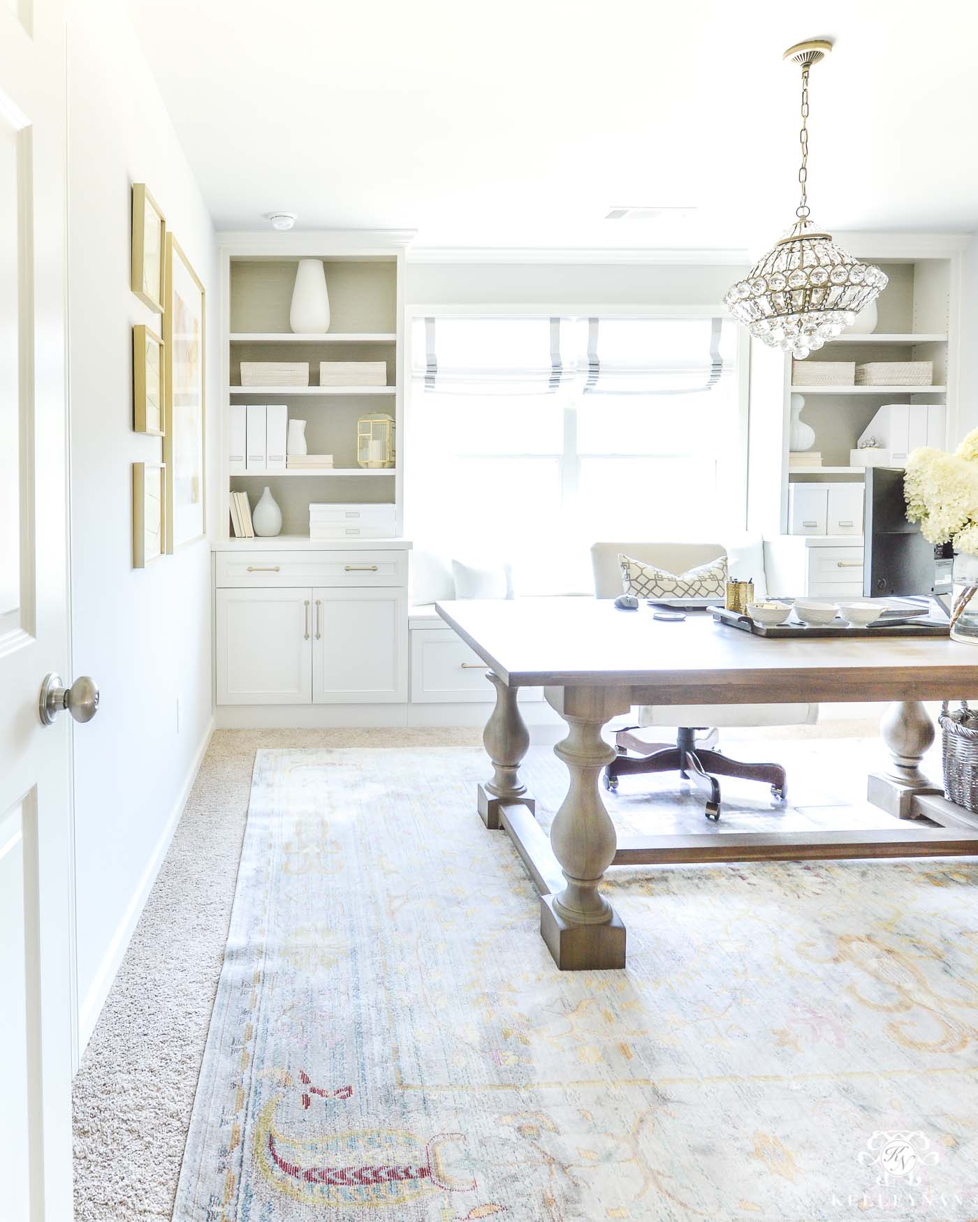 Home office with built-in shelving and chandelier