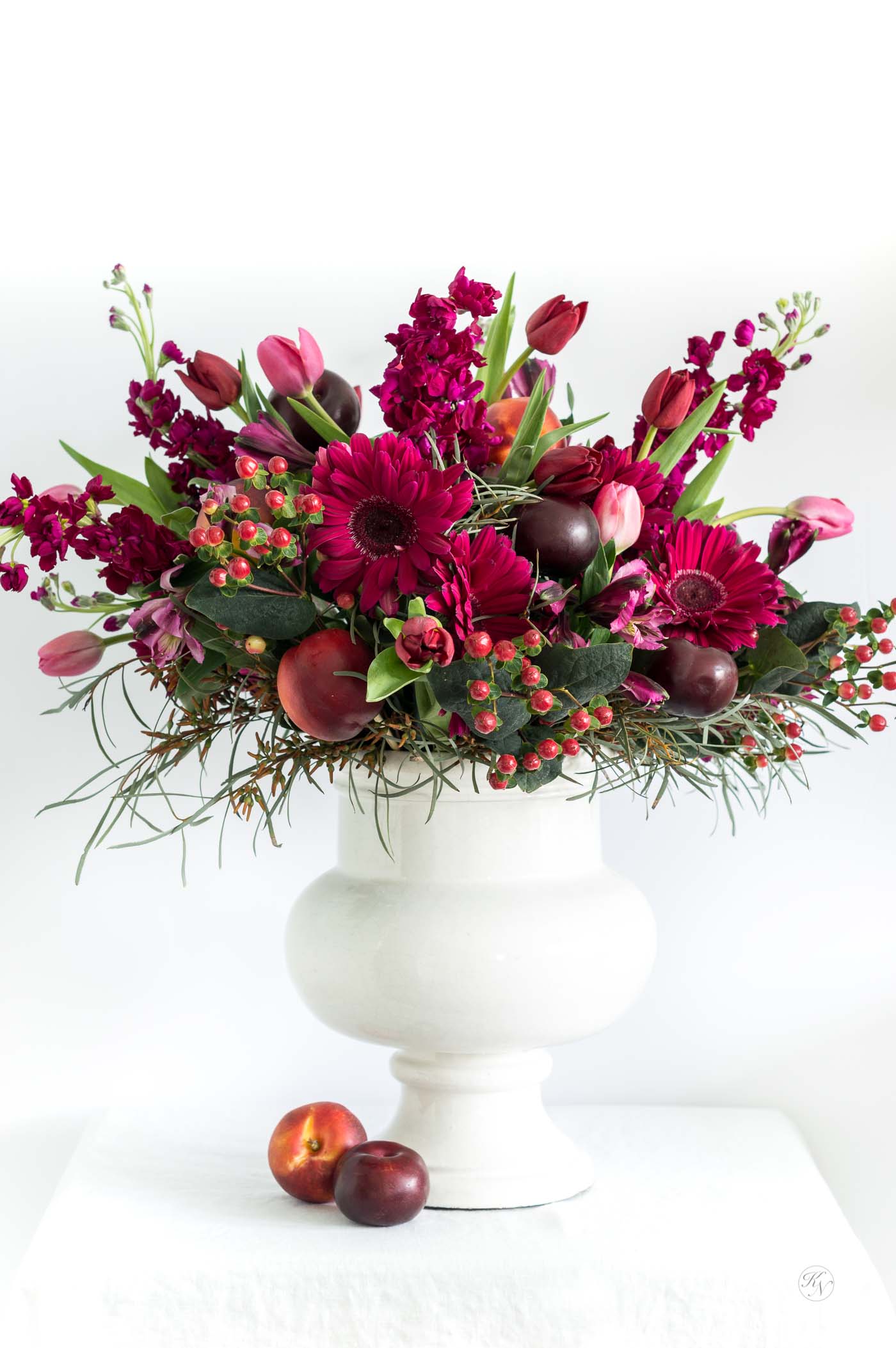 Red, pink, and purple fruit and floral color scheme for a grand arrangement - perfect for a wedding! 