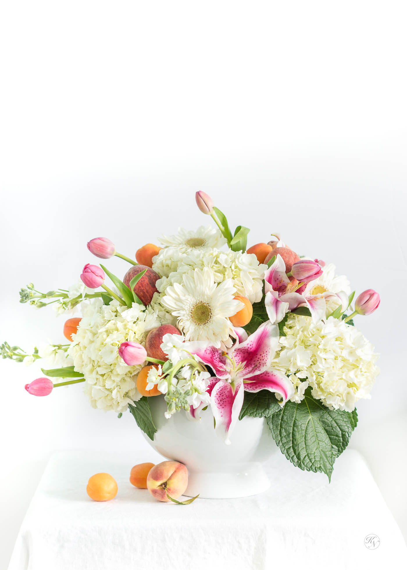 How to create a fruit and floral centerpiece with peaches, apricots, and pink and white flowers