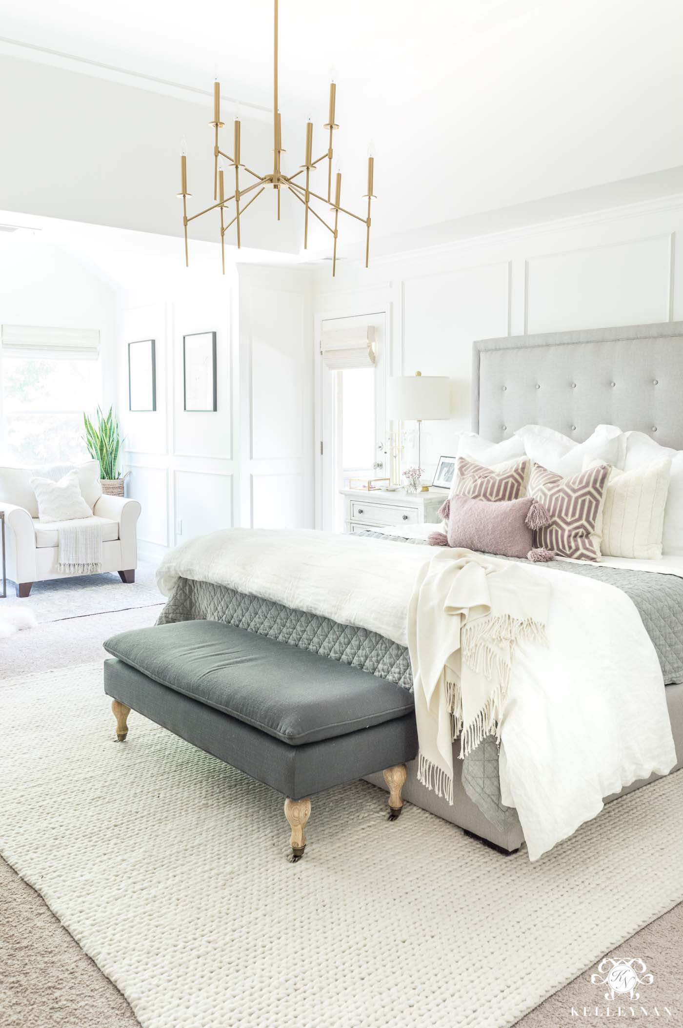 Mixing and matching bedroom furniture and tying together a neutral master retreat with a gray tufted bed and blush pillow accents