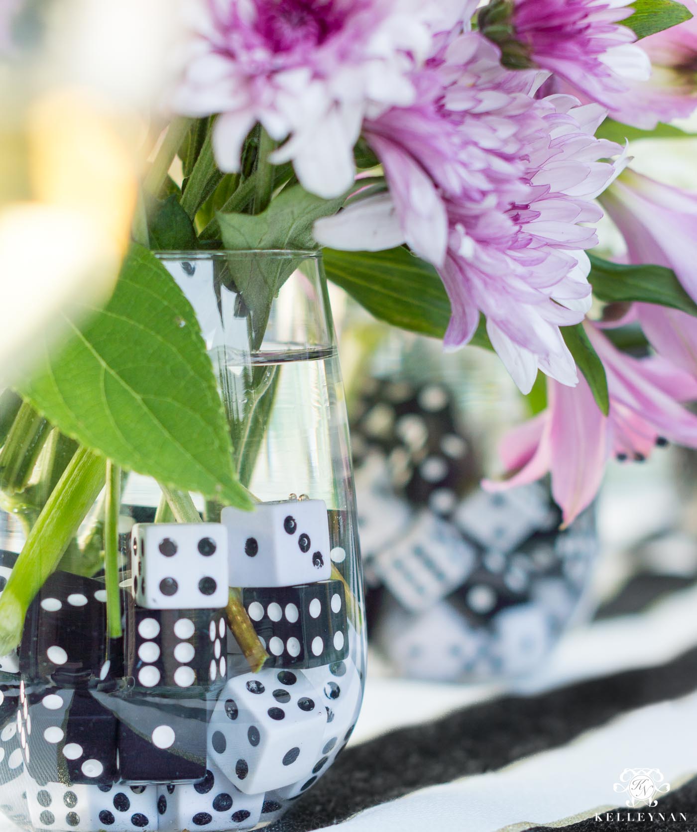 Idée de centre de table fleuri pour soirée de jeu avec des dés comme rochers dans le vase