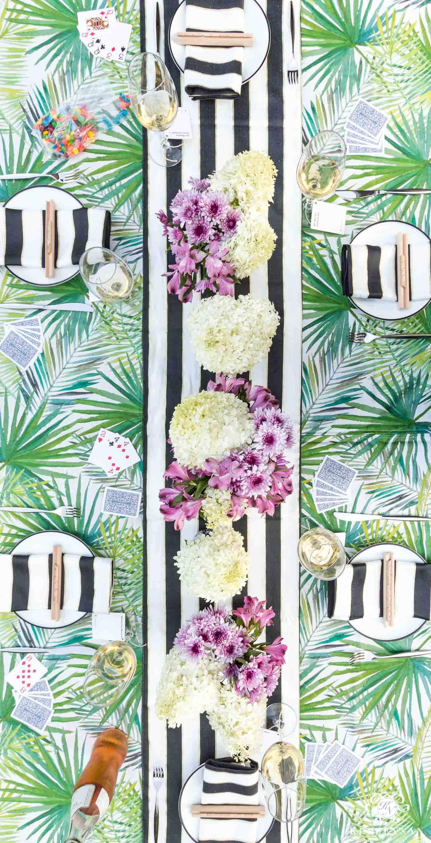 Pretty outdoor palm frontd and palmetto leaf table with black and white kate spade napkins and runner for game night