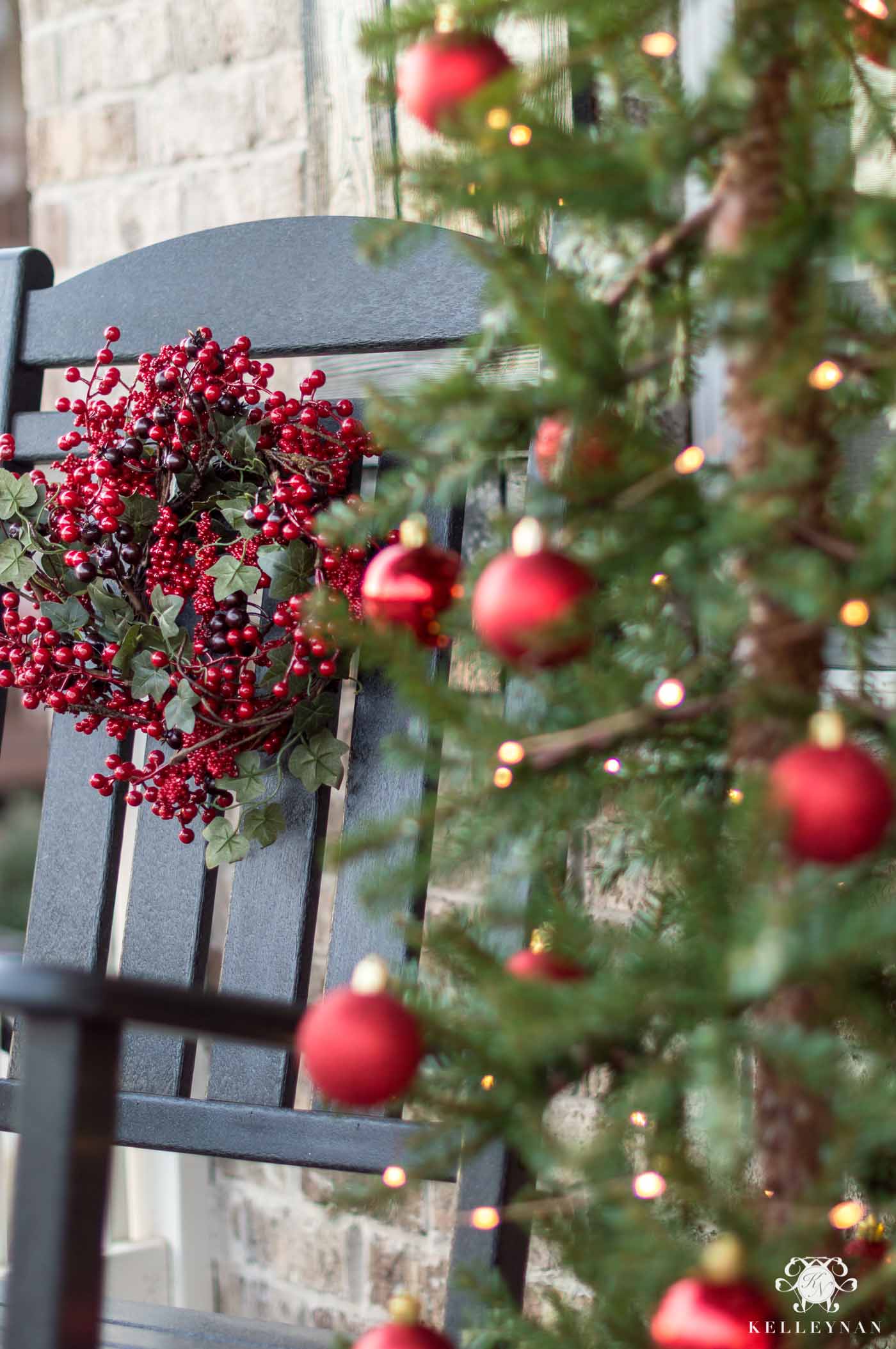 Front porch Christmas decorations and red berry wreaths on rocking chairs