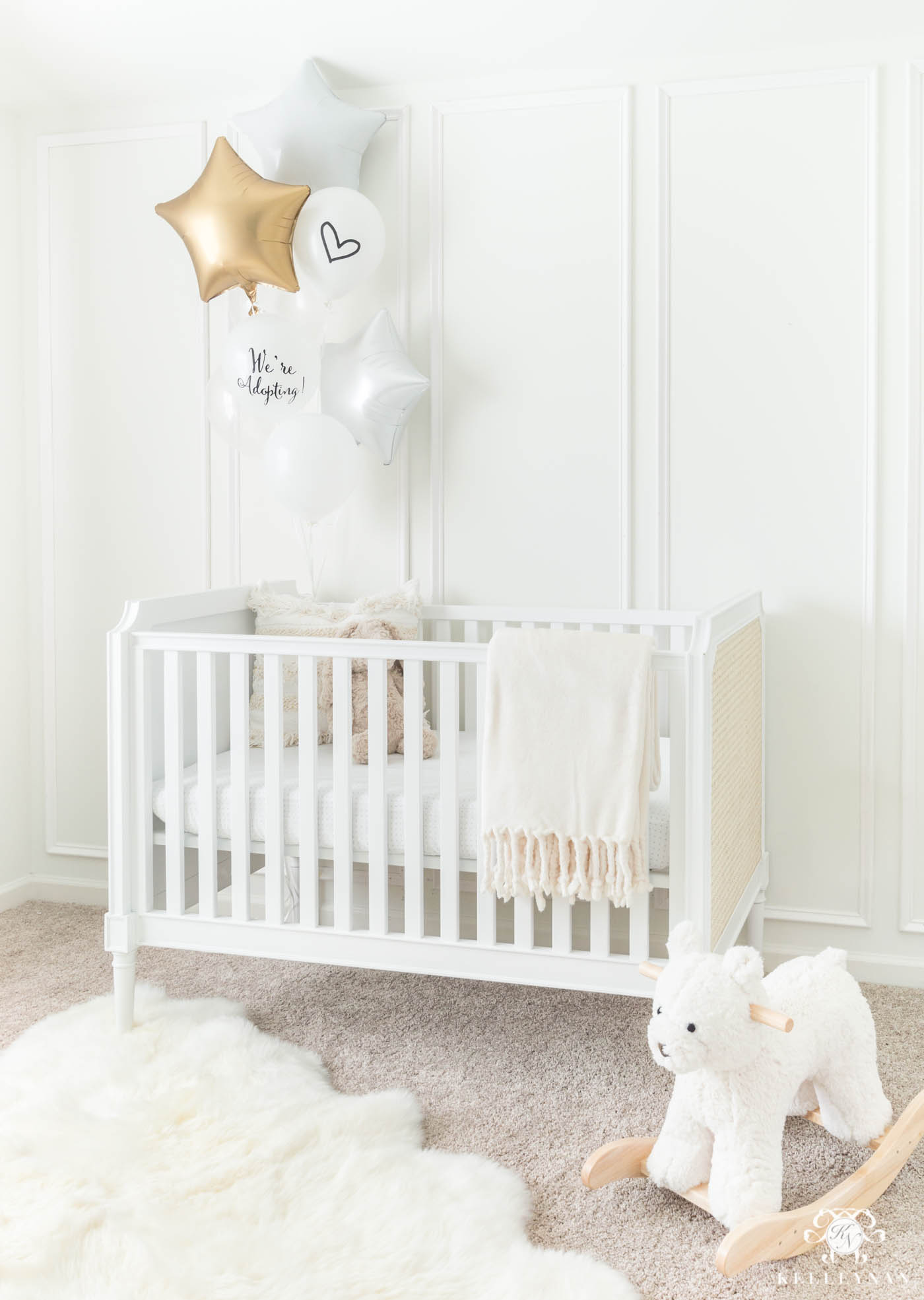 Baby adoption announcement idea using a nursery crib and balloons