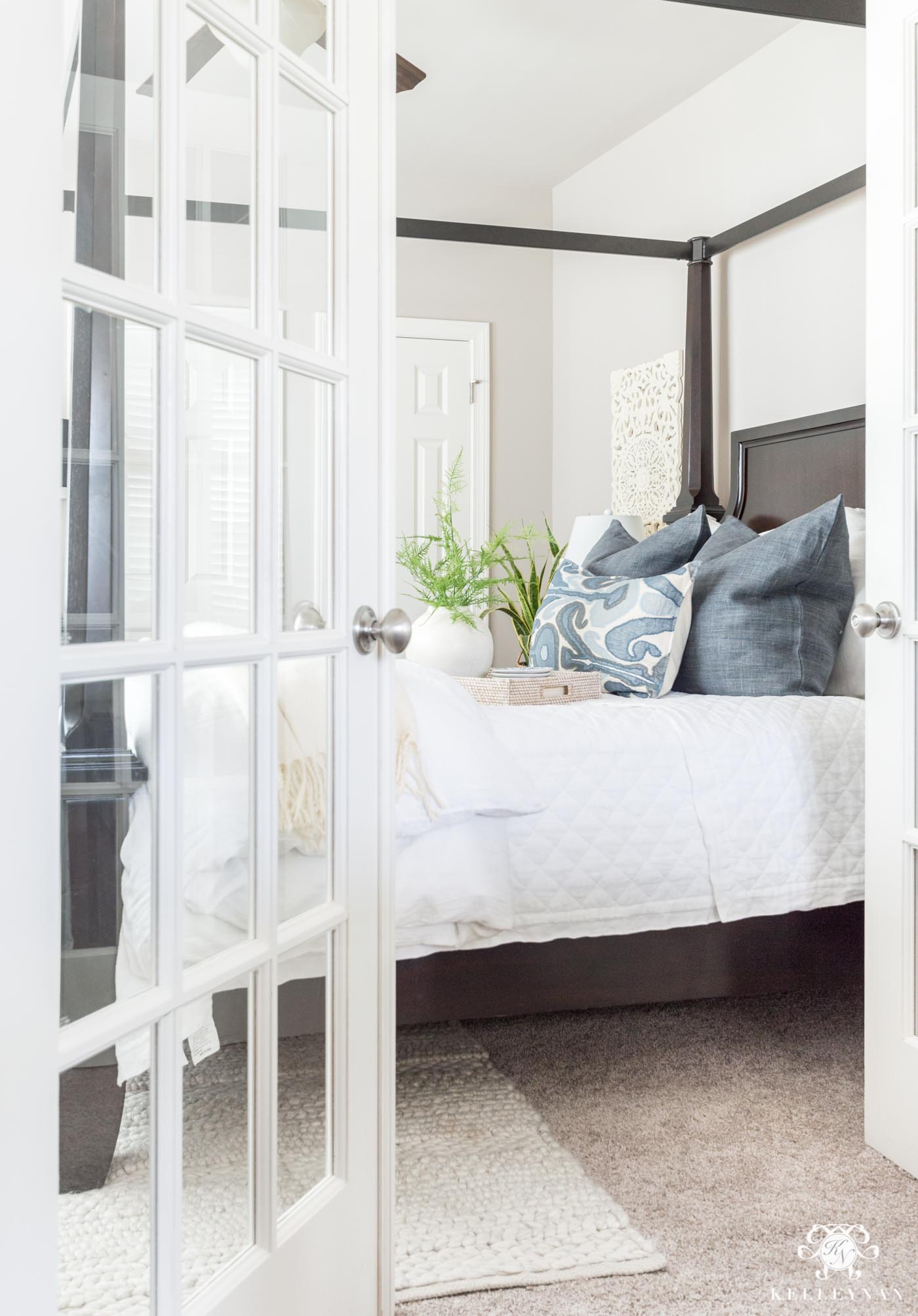 Guest bedroom canopy bed with blue and white classic bedding