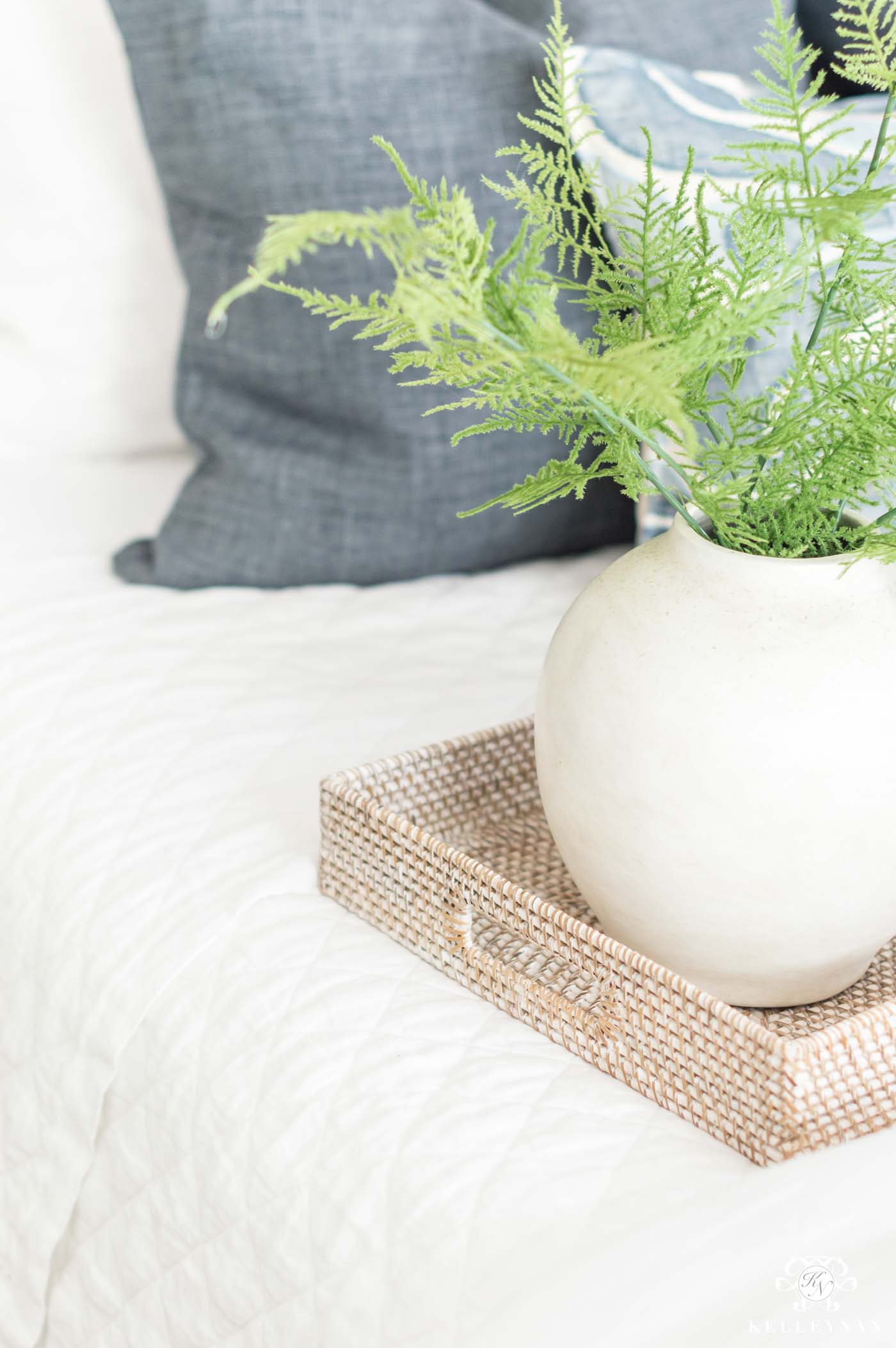 white vase with greenery and asparagus ferns