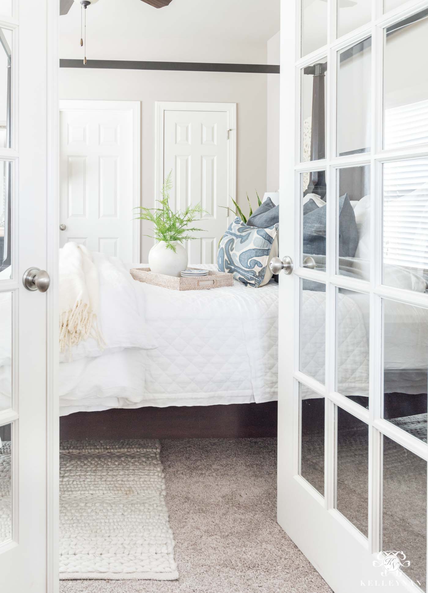 French doors leading to a blue and white guest bedroom