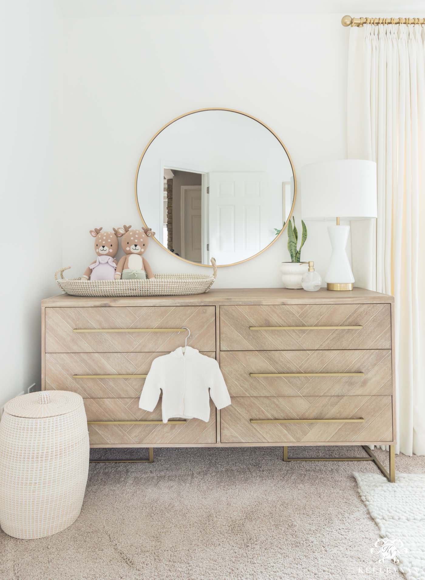 Nursery changing station on a double dresser with pretty woven changing basket