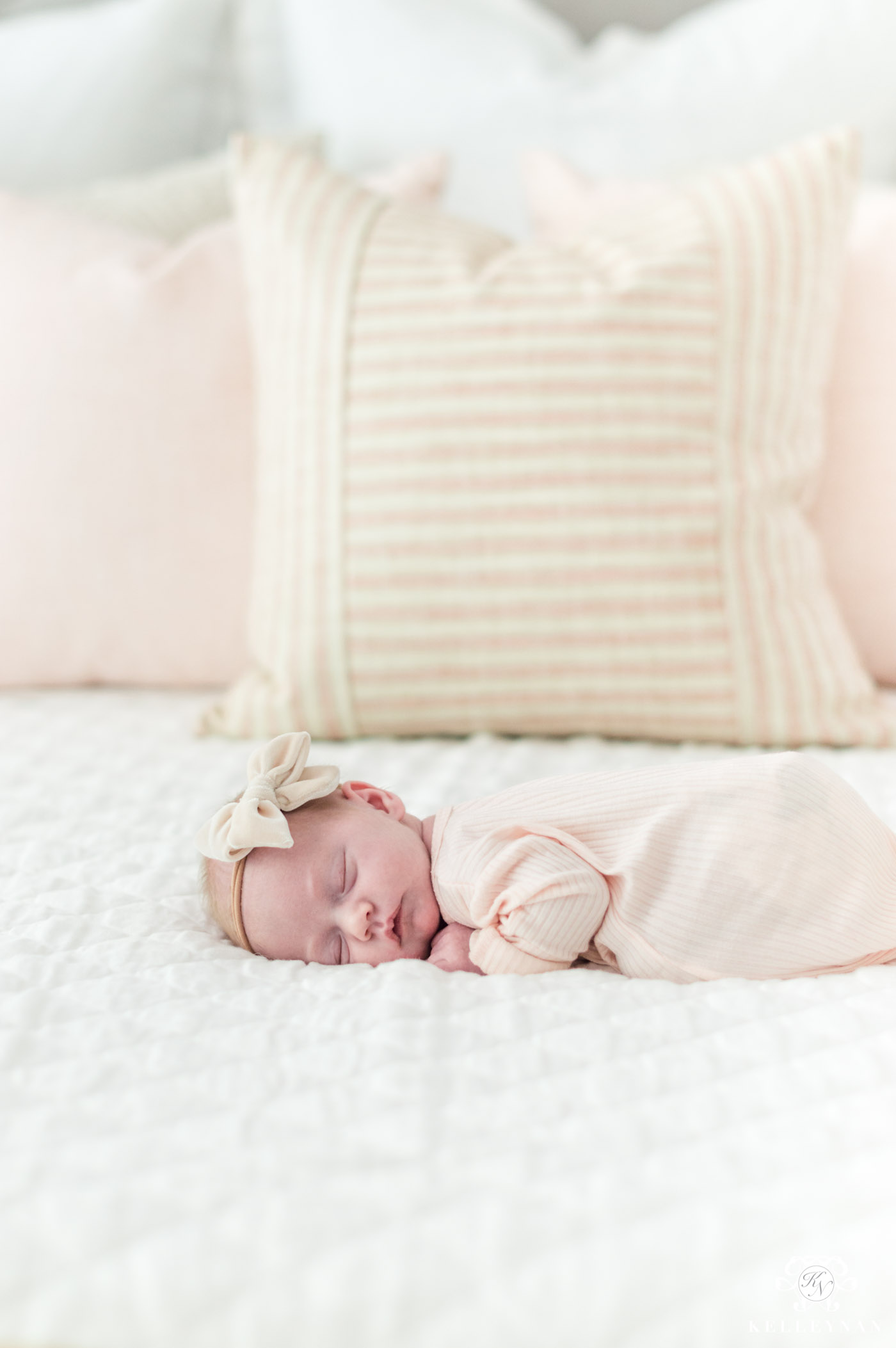 Little girl newborn photo with white and pink bedding