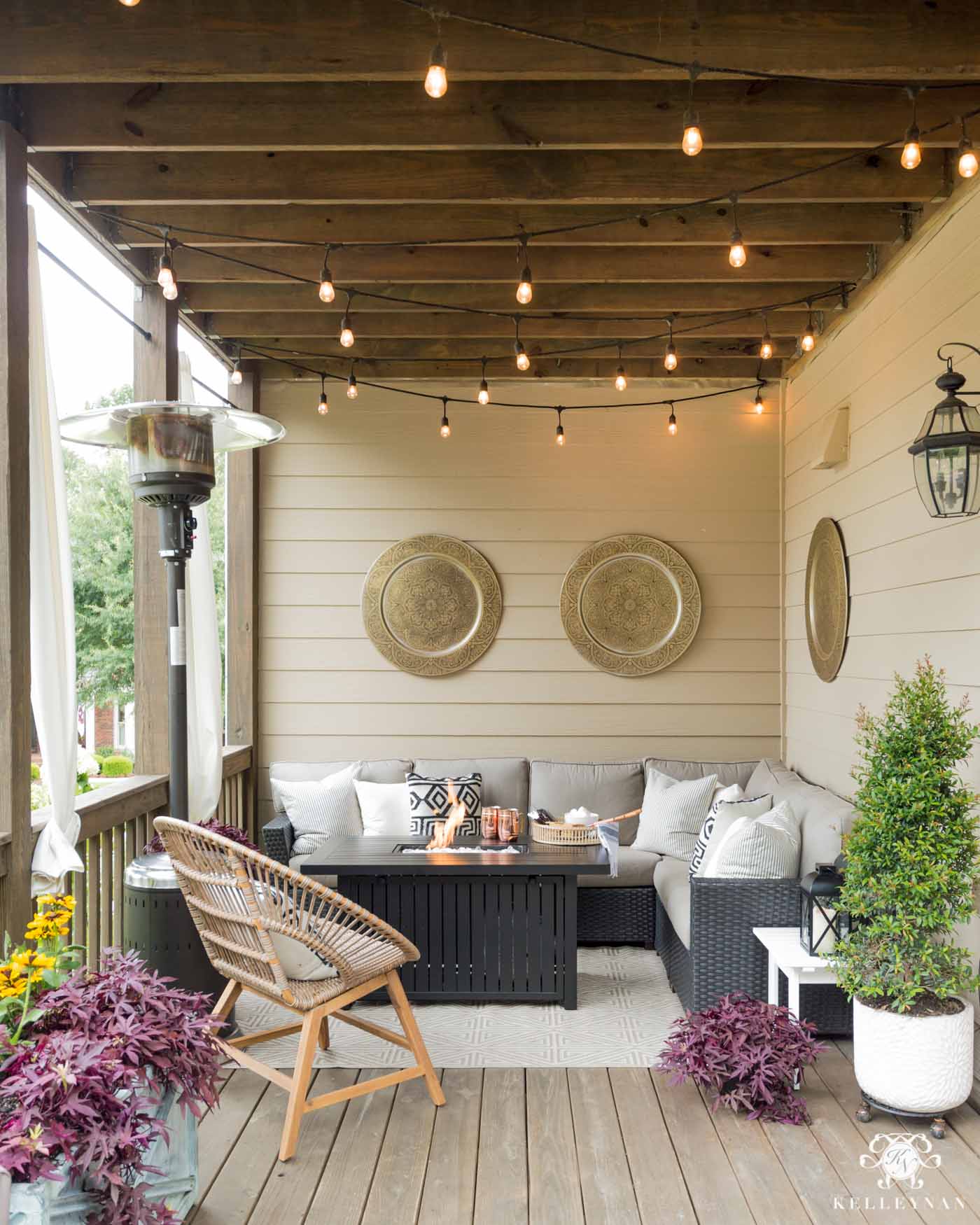 Summer to fall outdoor living decor with twinkle lights, a heat lamp, and fire pit table