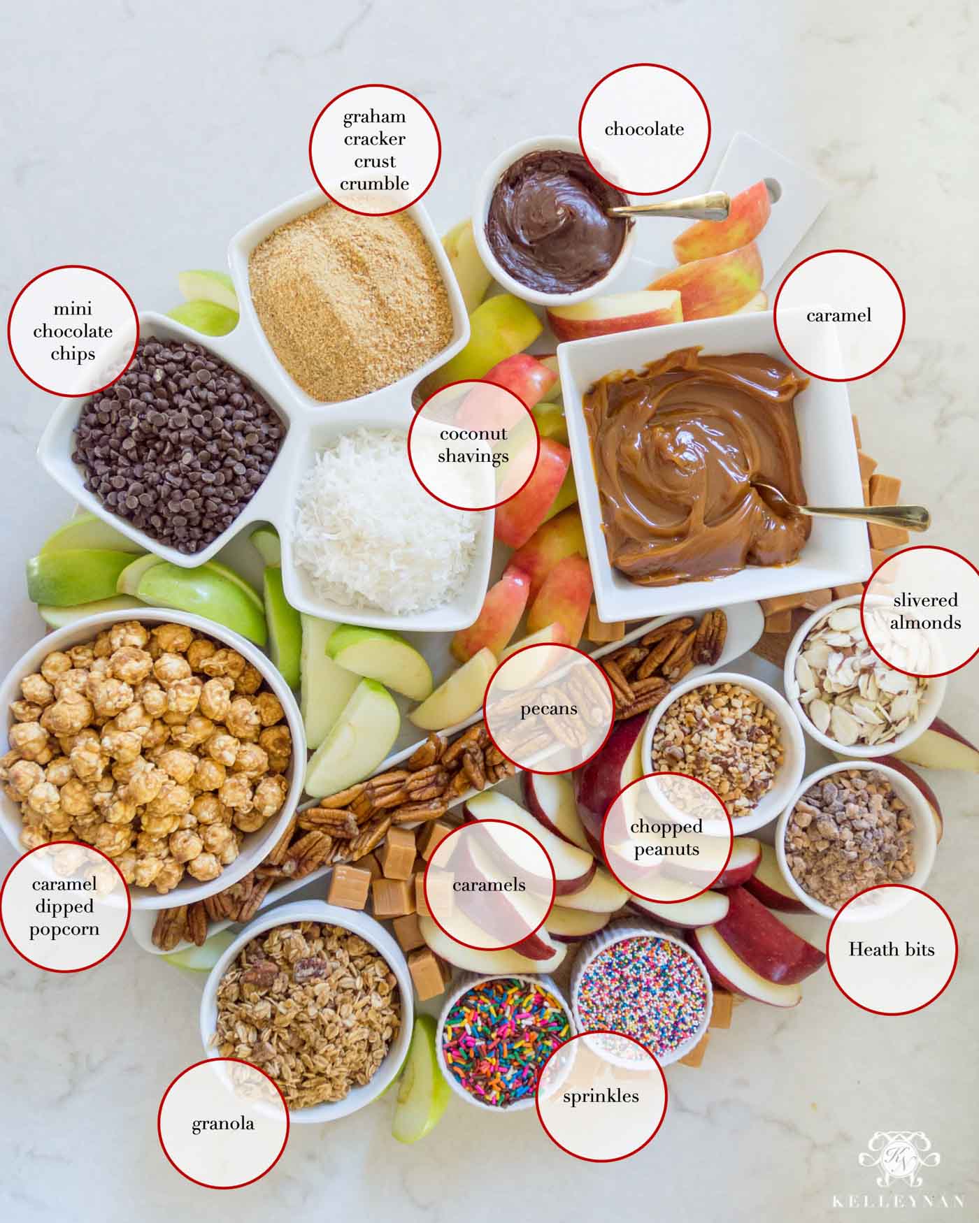 Sliced caramel apples and all the toppings for a fall caramel apple board