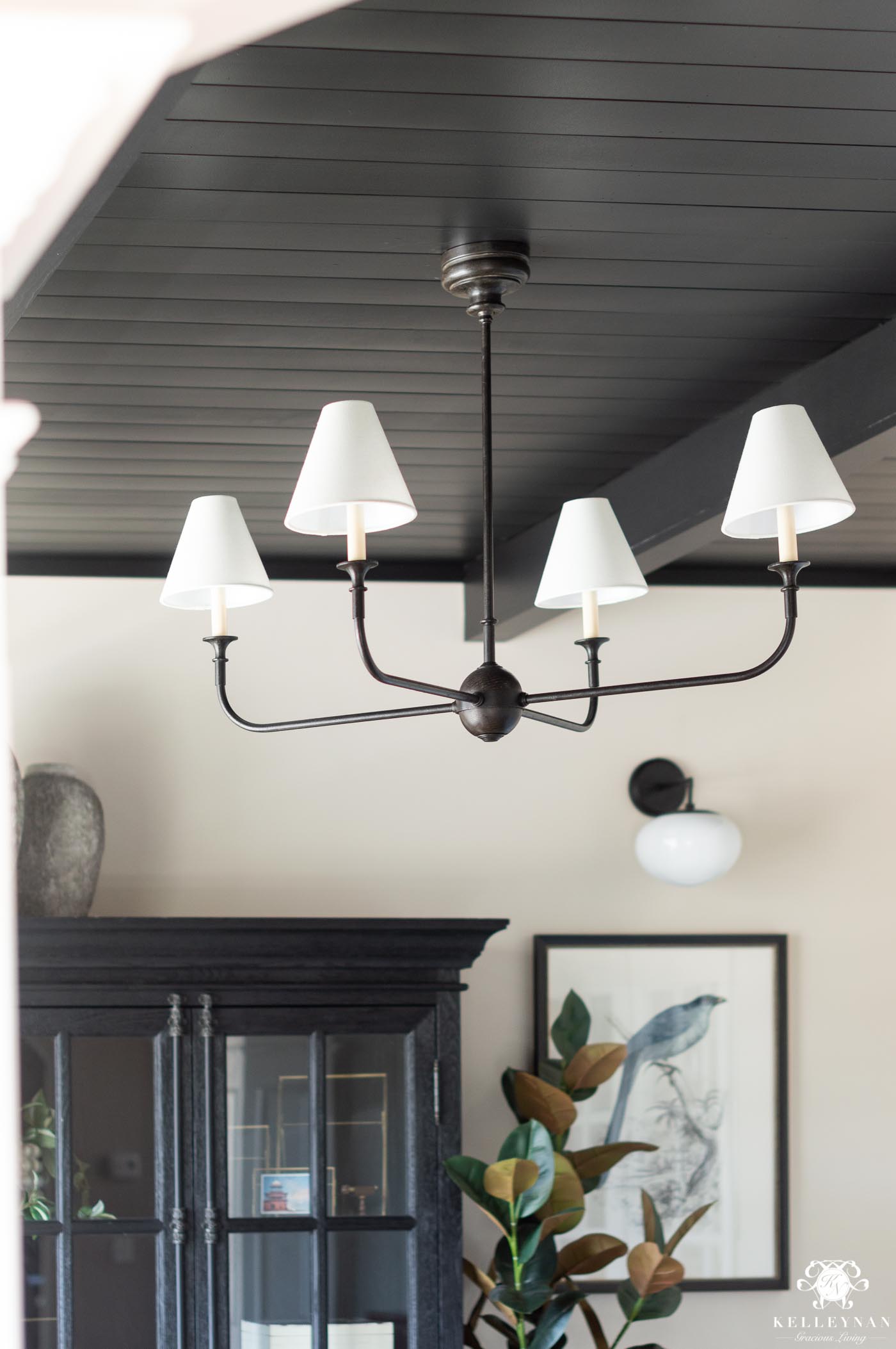 statement chandelier with a black planked shiplap ceiling with black beams