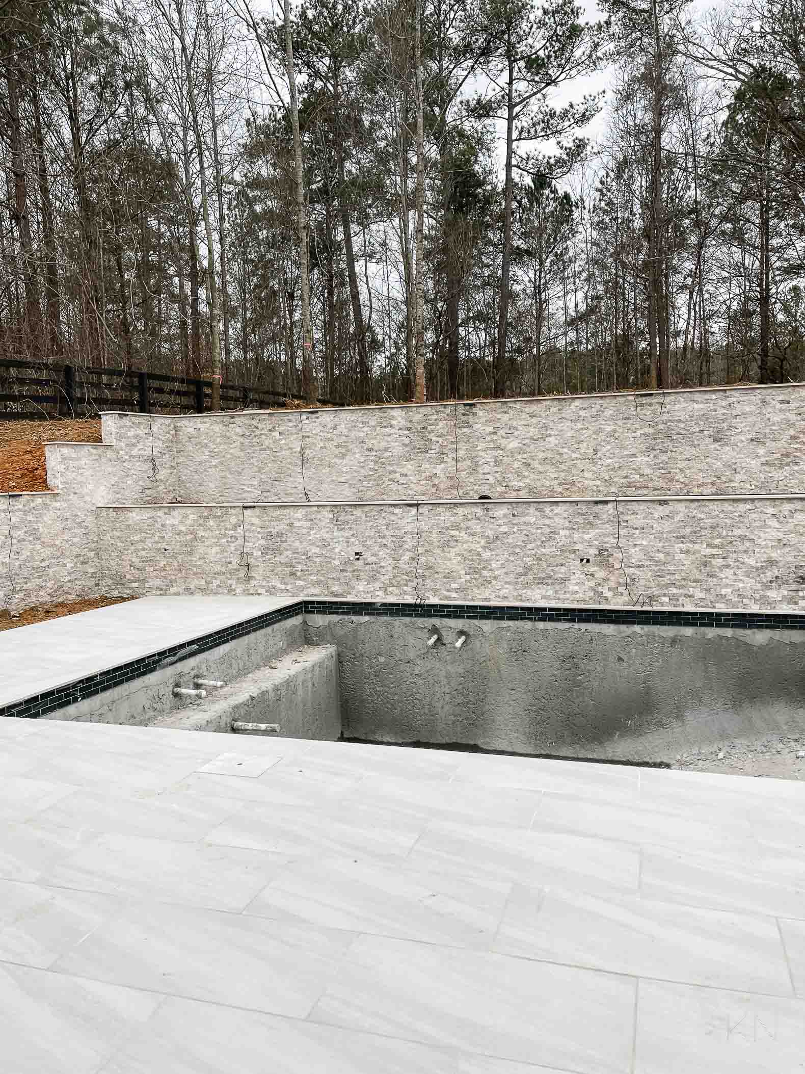 Concrete Pool Building Progress with Retaining Walls