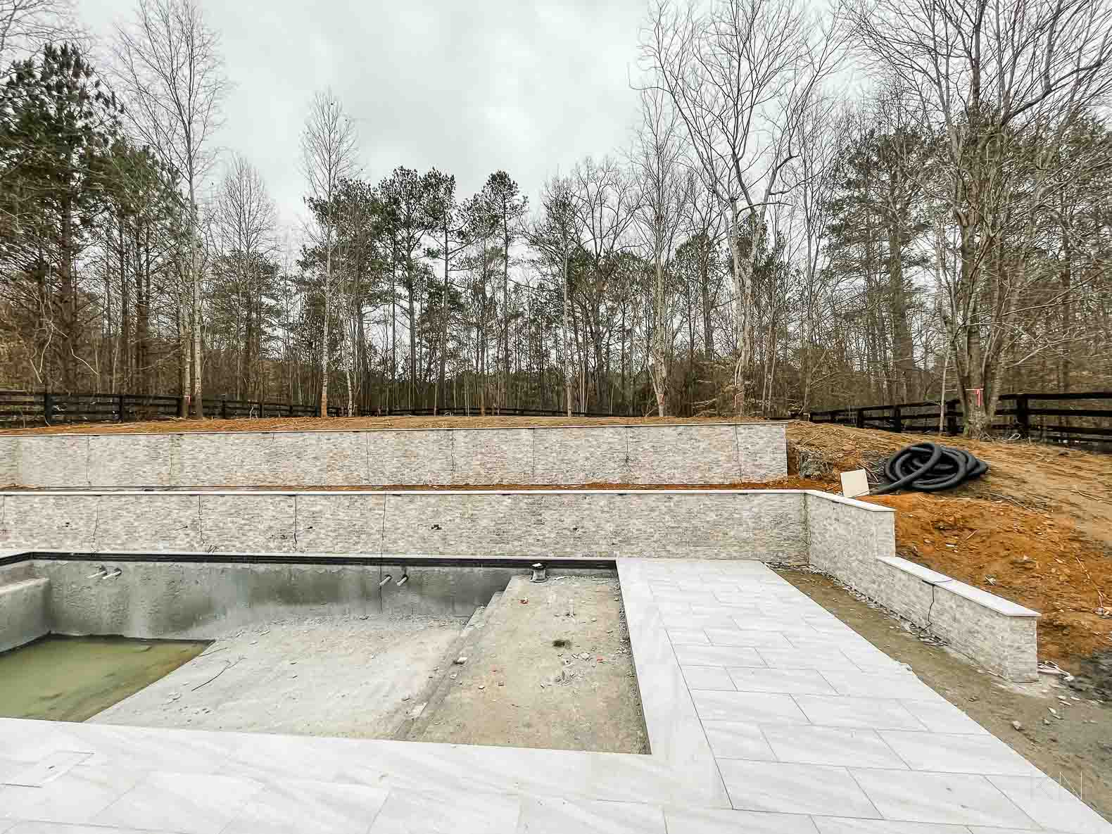 Concrete Pool Building Progress with Retaining Walls